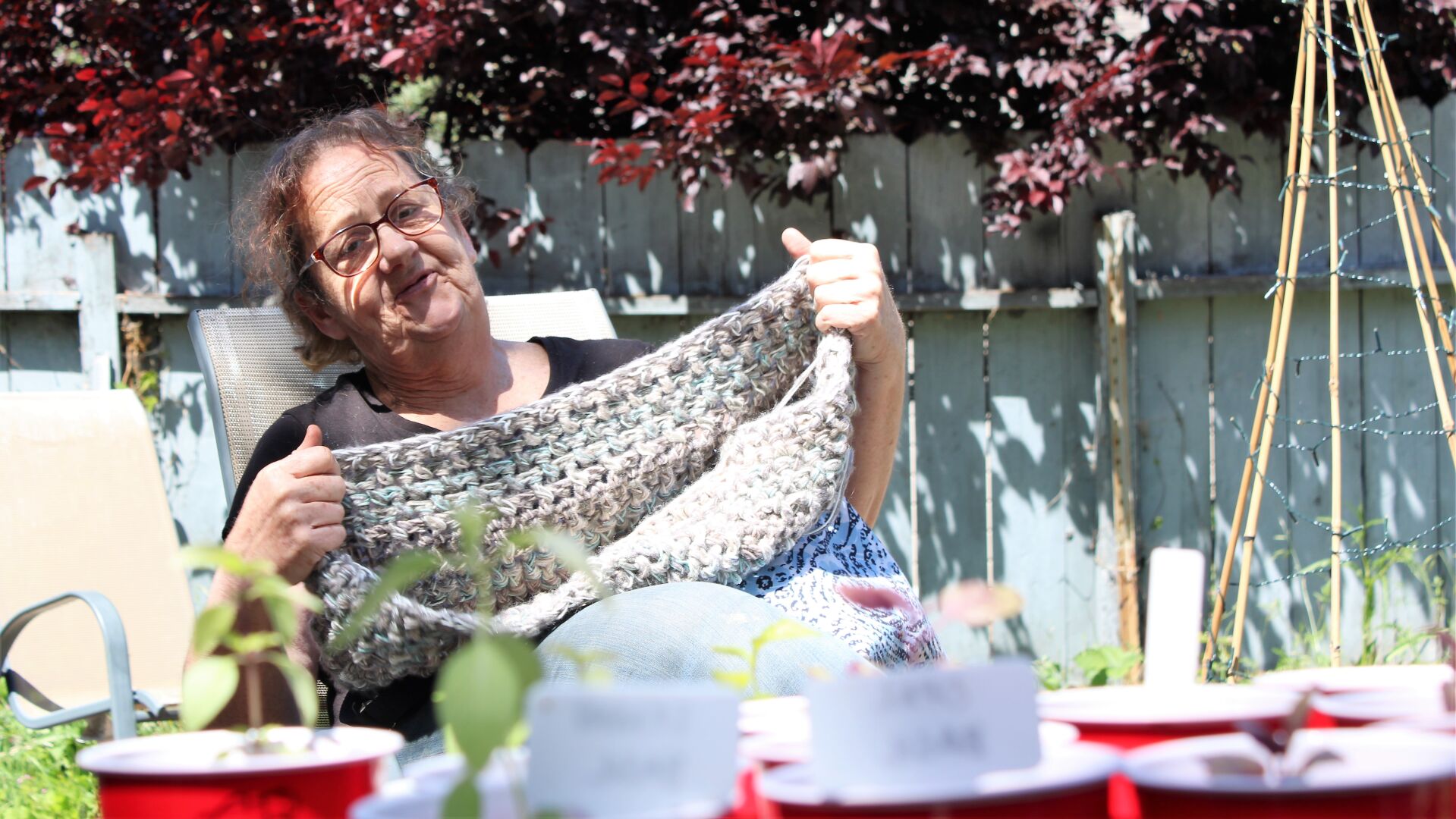 Jenn Corleone crocheting in her garden